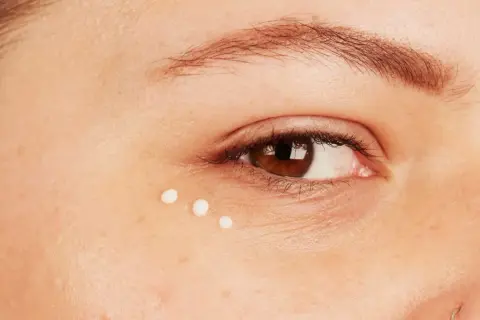 Trois petites gouttes de crème illuminent le coin de l'œil, prenant soin des yeux sensibles.