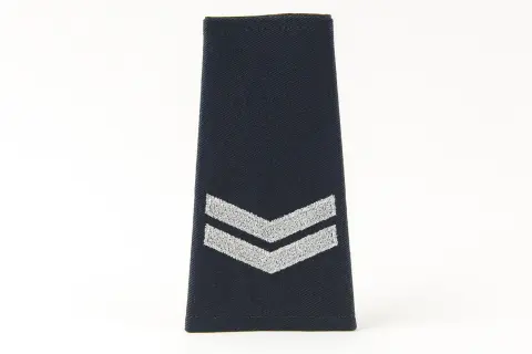 Granatowa naszywka z dwoma srebrnymi szewronami, symbolizująca stopnie w policji.