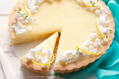 Deliziosa crostata al limone con meringhe e scorzette, una fetta è già stata servita.