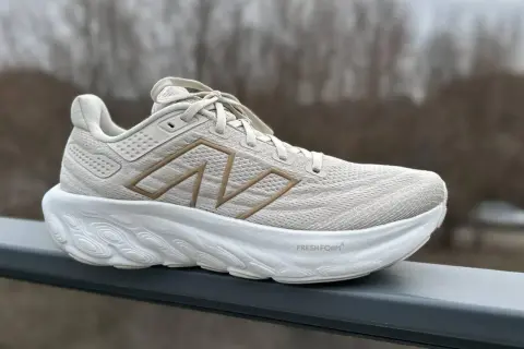 Jasny beżowy but sportowy z grubą białą podeszwą. Widoczny napis "Fresh Foam" i logo "N". To pokazuje, co to jest drop w butach – różnica wysokości między piętą a palcami.