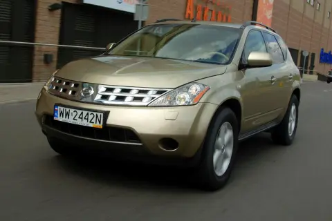 Złoty Nissan Murano 3.5 V6 w ruchu miejskim, z widoczną tablicą rejestracyjną WW 2442N.