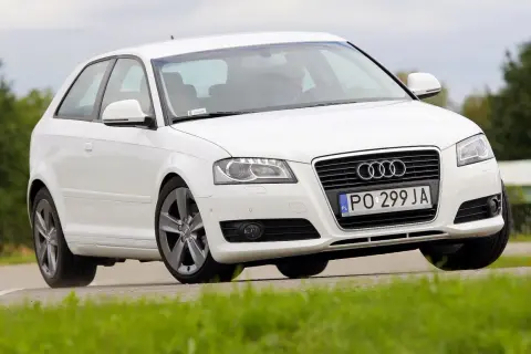Białe Audi A3 8P w ruchu, z widoczną żarówką stopu.