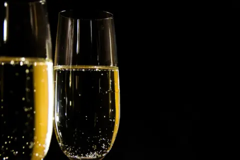Två glas med bubblande champagne redo att utbringa en skål.