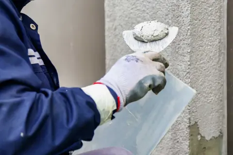 Pracownik nakłada tynk silikonowy. Sprawdź aktualną tynk silikonowy cenę za m2 robocizny.