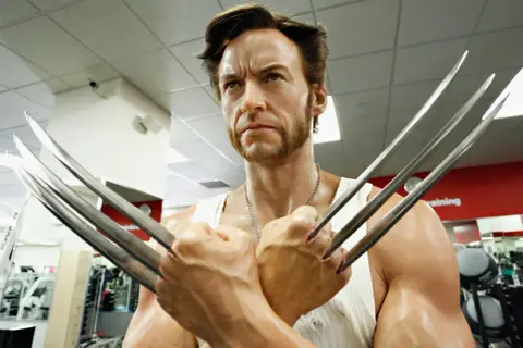 Wolverine, avec sa barbe distinctive et ses griffes rétractées, pose dans une salle de sport.