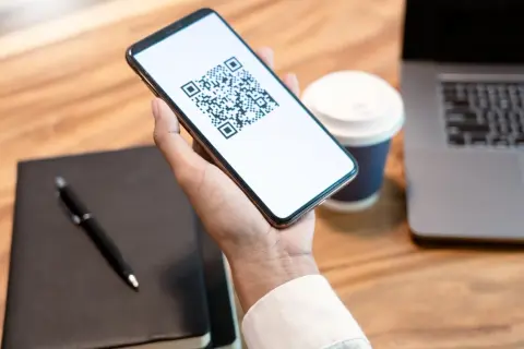 Smartphone con QR code per l'invalidità civile.