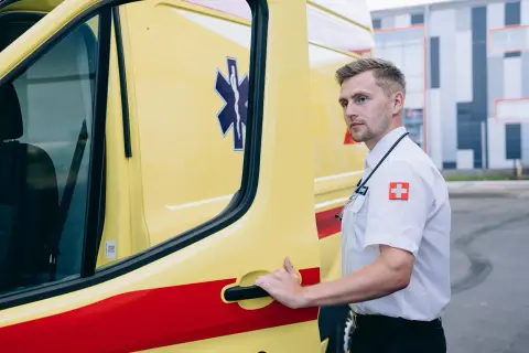 Ratownik medyczny przy karetce, gotowy do akcji. To on często jako pierwszy stwierdza zgon w domu.
