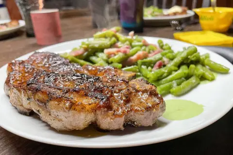 Un jugoso filete de carne magra, perfectamente cocinado, acompañado de judías verdes salteadas con tocino.