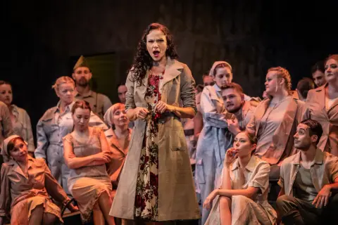 Carmen, w otoczeniu chóru, śpiewa z pasją, trzymając w dłoni czerwoną różę.