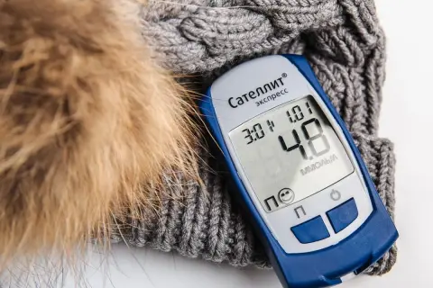 Glukometr na tle zimowej czapki. Czy wódka zbija cukier? Wynik 4.8 mmol/l.