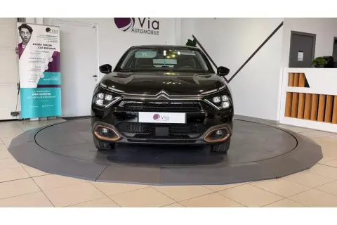 Une voiture noire sur un plateau tournant, prête pour un dépôt vente véhicule. Le logo Via Automobile est visible.