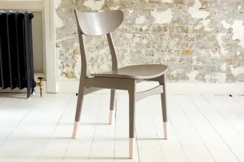 Grå pinnstol med ljusrosa "strumpor" på benen. En fin idé för att måla pinnstolar och ge dem nytt liv.