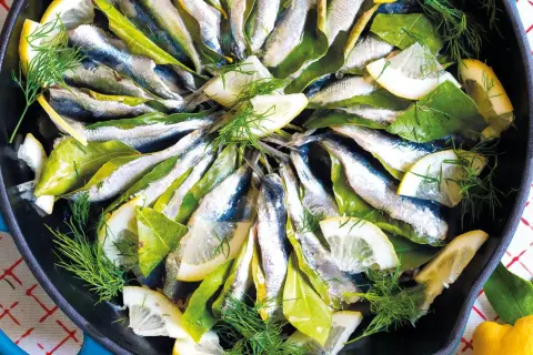 Sardine in padella con limone, alloro e finocchietto fresco, pronte per essere gustate.