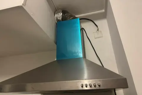 Hotte aspirante en inox avec conduit d'évacuation argenté. Il est temps de nettoyer filtre hotte pour une cuisine plus saine.
