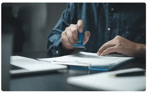 Main tenant appose un tampon sur un document. Le droit fixe d'enregistrement est de 125 €.