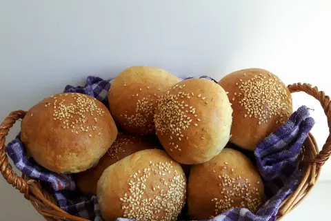 Koszyk pełen świeżych, pachnących bułek pszenno żytnich, posypanych sezamem. Idealne na śniadanie lub jako dodatek do obiadu.