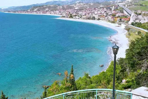 Vista panoramica delle spiagge di Reggio Calabria, con il mare cristallino che lambisce la costa e il borgo arroccato sulle colline.