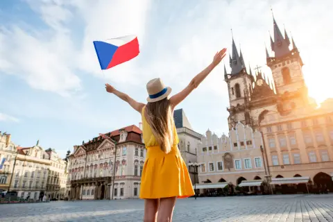 Kobieta z flagą Czech na Rynku Staromiejskim w Pradze. Słowa po czesku, radość podróżowania.