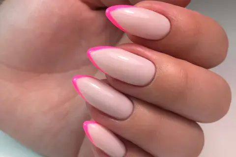 Manucure française tendance avec des pointes rose vif sur une base nude. Un look audacieux et chic.