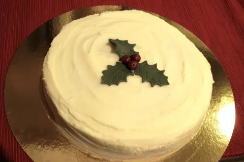 En krämig tårta med vit glasyr, dekorerad med en julstjärna av marsipan. Perfekt för julfikat!