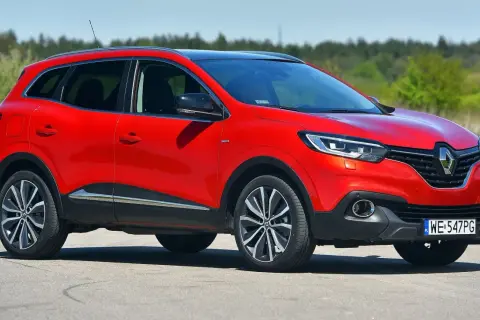 Czerwony Renault Kadjar na drodze. Wiele pozytywnych **renault kadjar opinie** potwierdza jego atrakcyjny wygląd i komfort jazdy.
