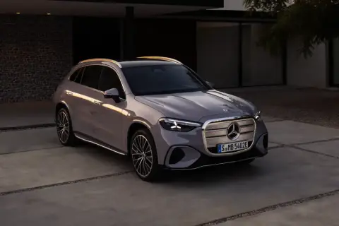 En elegant grå bil Mercedes står parkerad på en uppfart framför ett modernt hus.