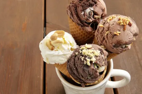 Cuatro helados en conos, dos de chocolate y uno blanco con cacahuates, perfectos como helados para diabéticos tipo 2.
