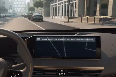 Vista interior de un BMW con mensaje de atención: "Tu BMW necesita una revisión".