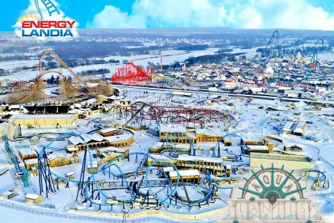 Zimowy krajobraz Energylandii z kolejkami górskimi i budynkami. To miejsce oferuje multisportowe atrakcje przez cały rok.