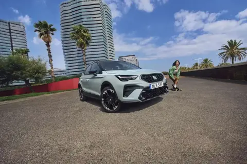 En Seat Arona står parkerad vid en strandpromenad med en person på skateboard i bakgrunden. Inga problem med denna bil.