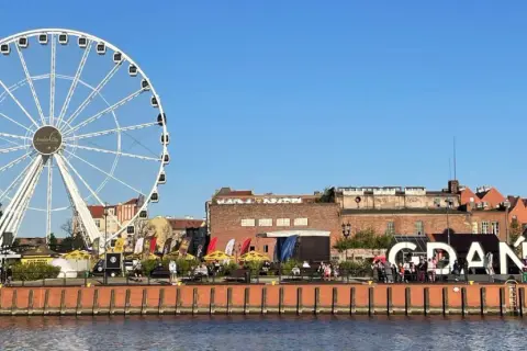 Ett stort pariserhjul och texten "GDANSK" syns vid vattnet. En fin plats att se i Gdansk.