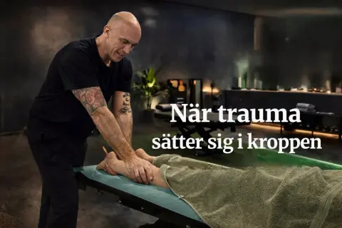 En man med tatueringar masserar en persons ben. Texten "När trauma sätter sig i kroppen" antyder en koppling till ptsd mening och kroppens reaktioner.