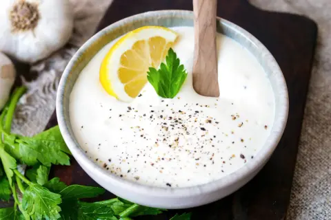 Cremiger knoblauch dip mit Zitrone und Petersilie, bestreut mit Pfeffer. Perfekt zum Dippen!