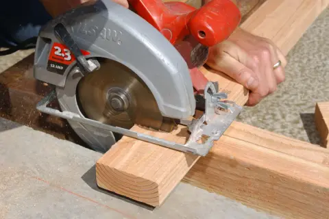 Maintenant, je me demande qui a inventé la scie circulaire. Un artisan utilise une scie circulaire pour couper du bois.