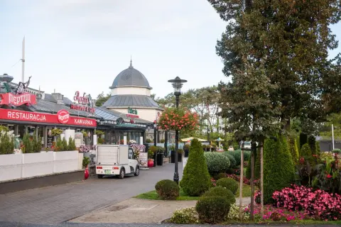 Urokliwy deptak w Międzyzdrojach, gdzie restauracje i kawiarnie zapraszają do odpoczynku. Wśród zieleni i kwiatów, to idealne miejsce na spacer i odkrywanie międzyzdrojskie atrakcje.