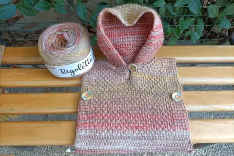 Uncinetto magico per un poncho colorato, con gomitolo Rigoletto e bottoni decorativi.