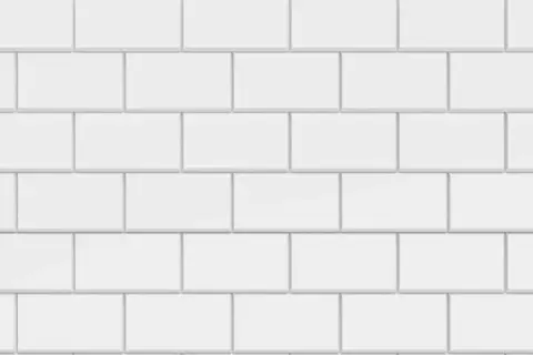 Vue rapprochée d'une pose carrelage métro blanche, avec des carreaux rectangulaires disposés en quinconce.