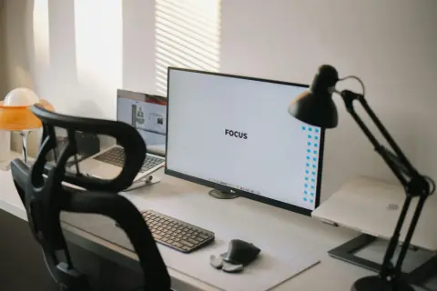 Ein aufgeräumter Schreibtisch mit dem Wort "FOCUS" auf dem Monitor, der eine "clean desk policy" verkörpert.
