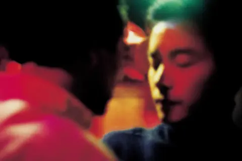 Un bacio intenso, un momento di passione tra due persone. L'atmosfera è carica di emozione, quasi come un sogno, un ricordo sfocato di Wing Shya.