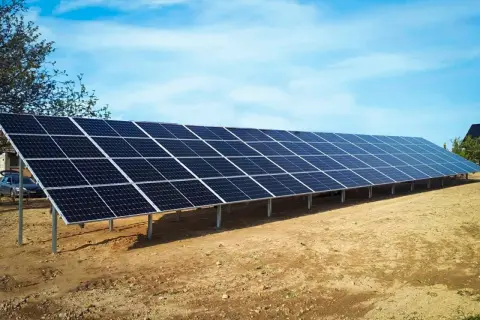 Długa instalacja fotowoltaiczna na stelażach, gotowa do zbierania energii słonecznej.