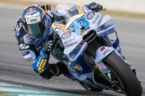 Alex Márquez inclinado en su moto azul y blanca, con el número 73 visible.