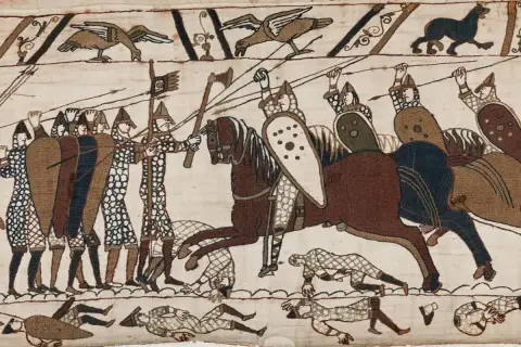 Scen från slaget vid Hastings 1066. Soldater med sköldar och spjut, en ryttare på häst. Nedanför fallna krigare.