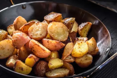 Goldbraune bratkartoffeln mit Ei, knusprig gebraten und würzig gewürzt, serviert in einer Pfanne.