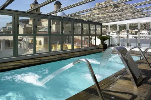 Piscina con cascadas y vistas a la ciudad, ideal para un spa bodyna Valencia.