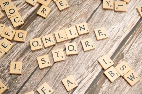 Litery na drewnianym tle układają się w słowa "ONLINE STORE". To wielka strategia dla każdego biznesu.