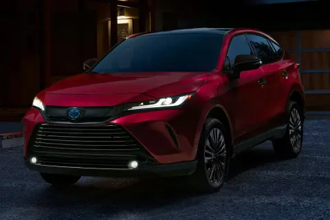 Elegancka, czerwona Toyota Venza błyszczy w wieczornym świetle, gotowa na nocną podróż.