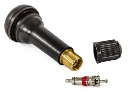 Pièce pour changer valve pneu : un corps de valve noir avec embout en laiton, un capuchon et le mécanisme interne.