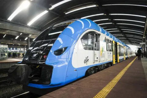 Niebiesko-biały pociąg PKP na peronie. Zastanawiasz się, jak zwrócić bilet PKP kupiony przez internet bez rejestracji? Sprawdź procedury online.