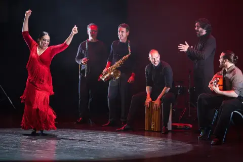 Fuensanta la Moneta, bailaora flamenca, levanta los brazos con pasión. La acompaña un grupo de músicos con saxofón, clarinete, cajón y guitarra.