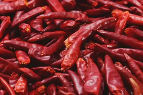 Góra suszonych, czerwonych papryczek chili, pełnych kapsaicyny, gotowych do dodania ostrości.